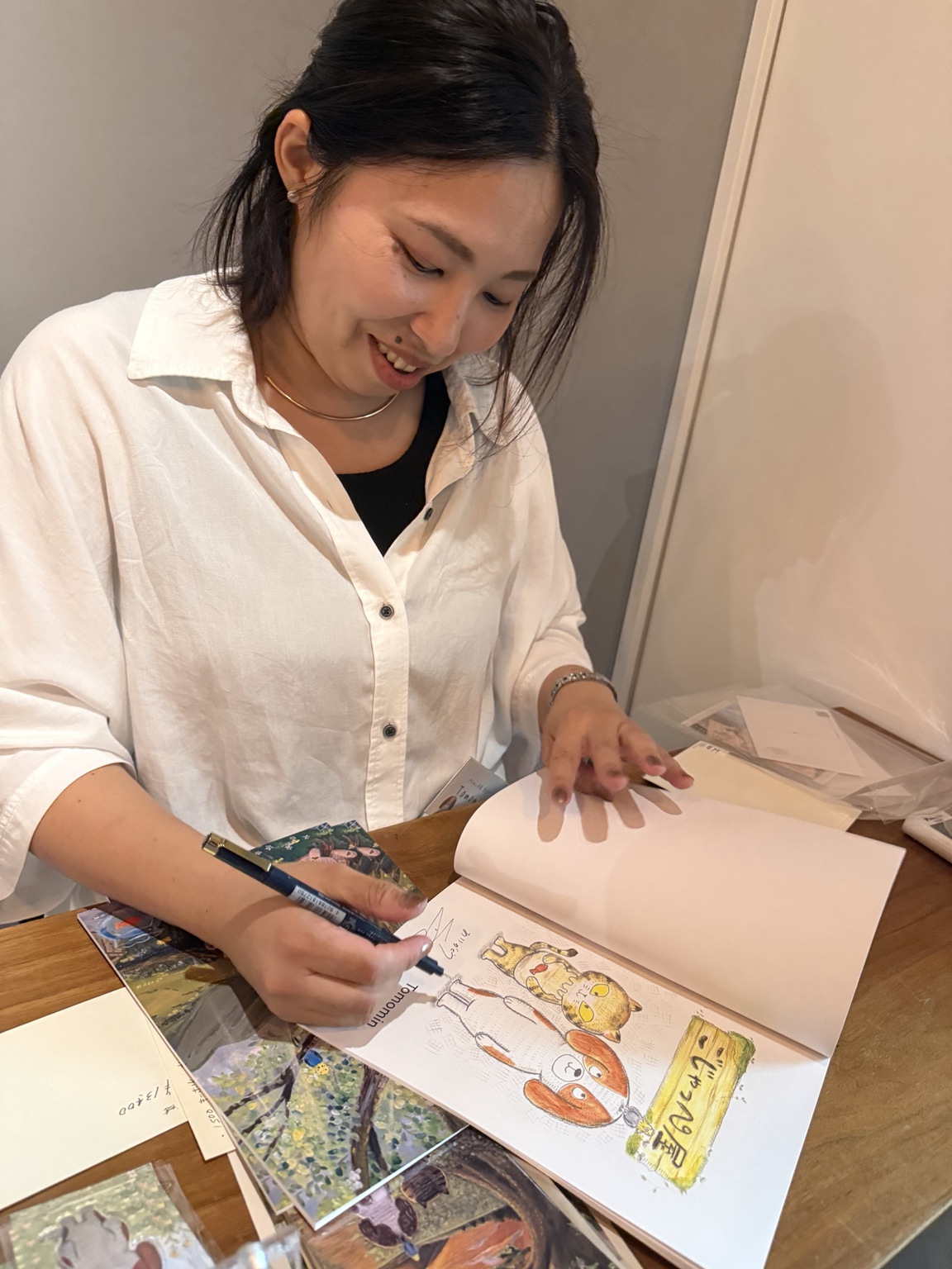 絵本にサインしている岡 知美